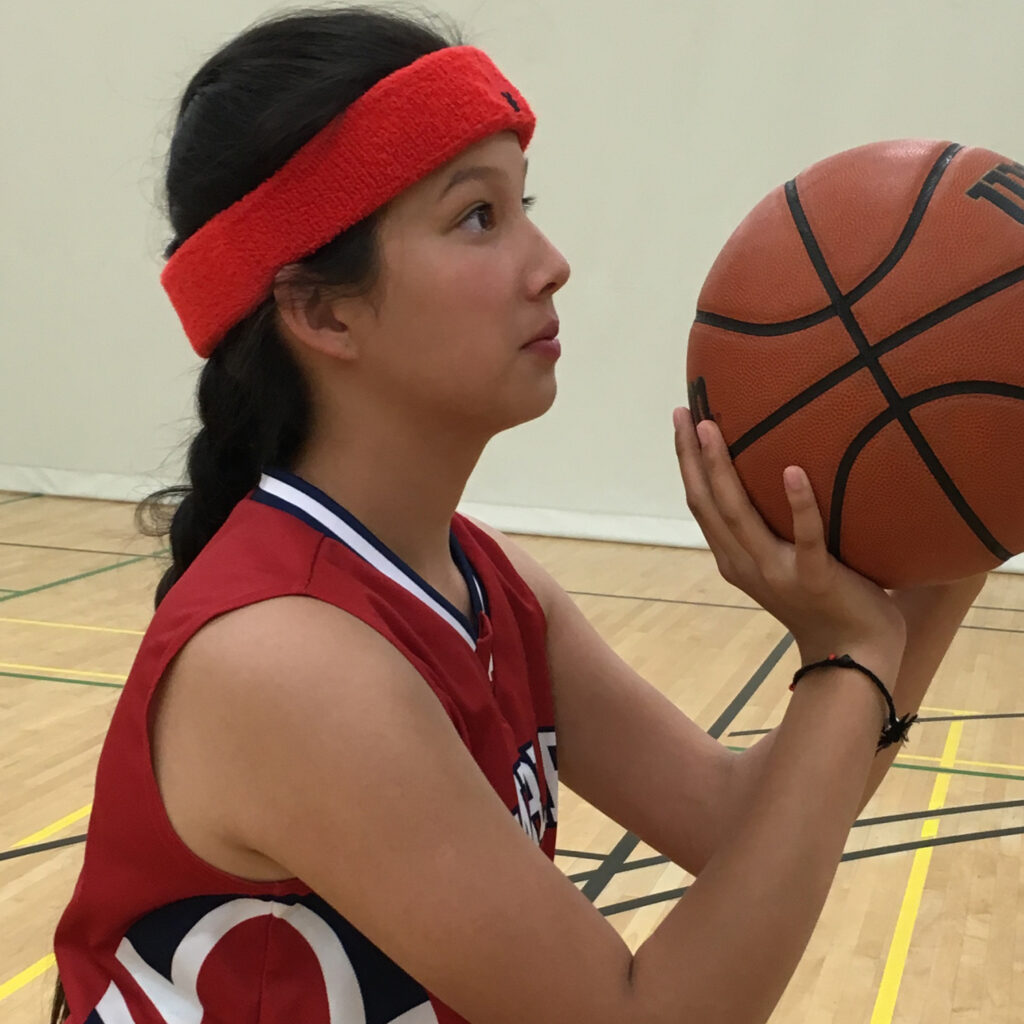 Anna is wearing a protective sweatband in red with a bold leaf insignia.