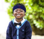 Protective headband by Forcefield® worn by a smiling young child outdoors, designed to provide extra head protection during high-risk activities or sports.