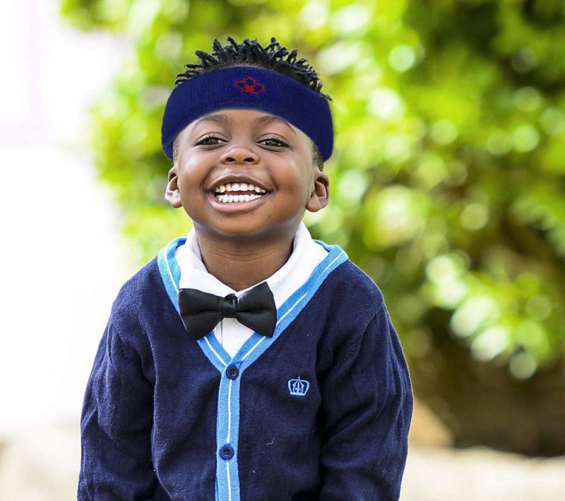 Protective headband by Forcefield® worn by a smiling young child outdoors, designed to provide extra head protection during high-risk activities or sports.