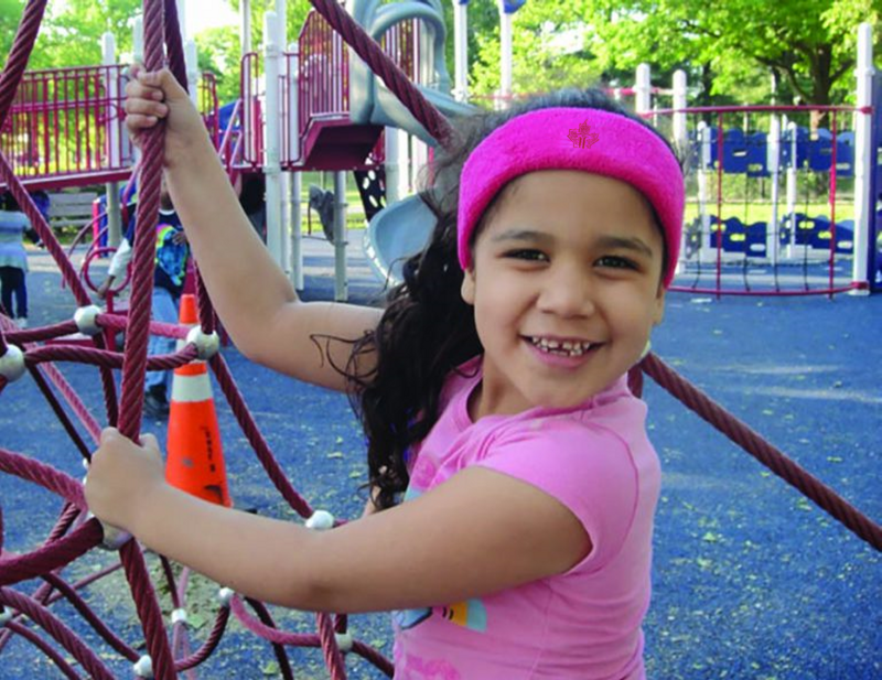 Pink fuzzy headband with logo, suitable for children or active kids, offers a stylish and protective accessory for outdoor play or sports.